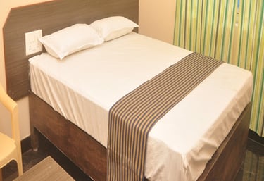 Clean and comfortable room at Hotel Aishwariyam Thirukadaiyur hotel near Abirami Temple