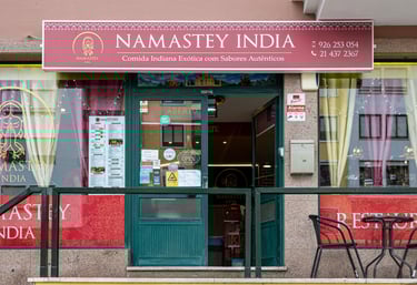Exterior storefront of Namastey India, an authentic Indian restaurant with menu and outdoor seating.