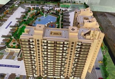 Architectural scale model of a modern high-rise residential complex with a swimming pool and landscape amenities.