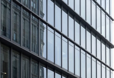 An abstract, minimalist architectural shot of a modern glass and steel facade of a tech company headquarters in a US city, with crisp lines and high contrast.