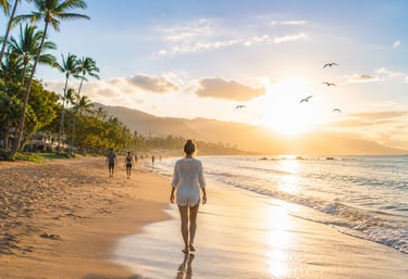 Mulher caminhando na praia ao amanhecer