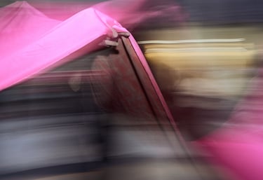 Abstract motion blur featuring vibrant pink fabric folds with dramatic lighting and dark shadows.