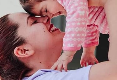 Madre feliz levantando a su bebé sonriente, compartiendo un momento de vínculo afectivo y conexión e