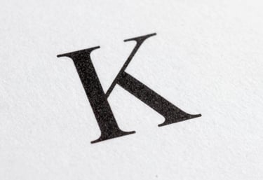 Macro shot of elegant black serif typography printed on high-quality matte white paper. Clean and minimal, International / General.