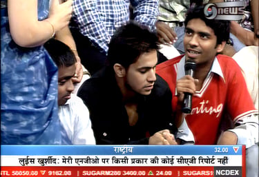 a man in a red shirt is holding a microphone
