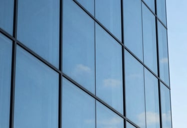 An abstract image of high-quality glass architectural panels reflecting a clear blue sky, representing clarity and modern business ethics, Brazilian setting.