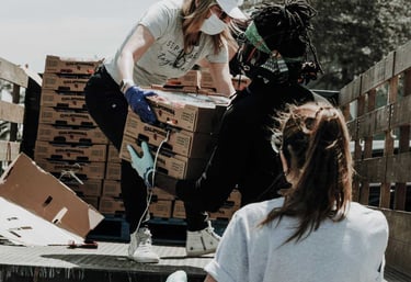 voluntarios ayudando a distribuir mercancia que acaba de llegar al banco de alimentos