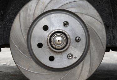 Close-up of a technician carefully replacing brake pads on a car in a cozy local shop.