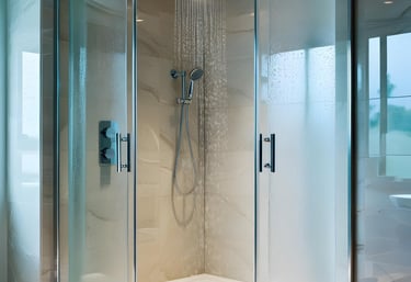 Curved glass shower with overhead rain shower in a renovated Auckland bathroom