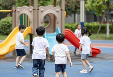 Smiling children of diverse backgrounds playing together outdoors in a sunny park.