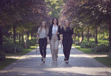 three women walking down a path in a park