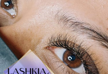 Primer plano de los ojos de una mujer con extensiones de pestañas negras, largas y densas realizadas