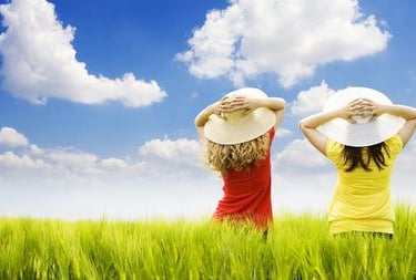 two women in hats standing in a field