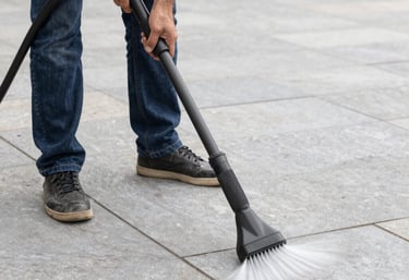 A sparkling clean stone patio surrounded by lush greenery after pressure washing.