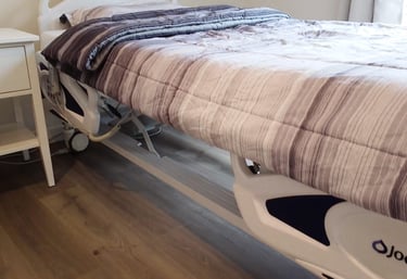 Adjustable medical bed in a comfortable AFH room, supporting safe rest, mobility, and daily care for residents.