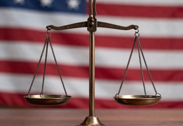 A close-up of a bronze scale of justice resting on a wooden desk, with a blurred US flag in the background, sharp focus, North American / US.