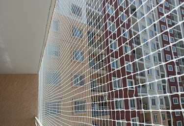 Wide shot of a high-rise balcony fully secured with safety nets overlooking Malabar Hill.