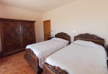 Camera doppia B&B Saludecio con due letti king size e arredi classici.
