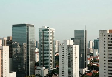 A panoramic view of a modern South American / Brazilian city skyline from a high-floor glass executive suite. Soft emerald and mist white tones.