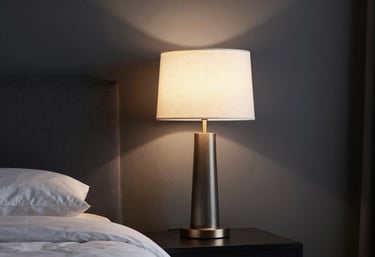 A sophisticated designer lamp casting warm light onto a charcoal wall in a luxuriously decorated Southern European / Spanish (Madrid) bedroom.