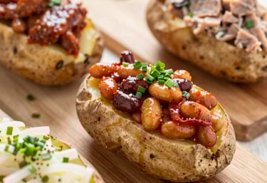 A rustic wooden table set with a hearty plate of fish and chips and a pint of amber ale.