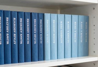 A shelf in a Western European / French office containing professional books on psychology, organized neatly with ocean blue and soft dusty blue bindings, bright and clean.