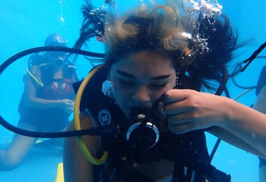 Alumna del curso Open Water DIver entrenando habilidades de máscara y autocontrol en piscina 