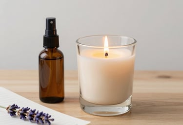 A tranquil bedside arrangement featuring a lit scented candle in a beige glass holder, a small spray bottle of lavender linen mist, and a notebook on a clean wooden surface.