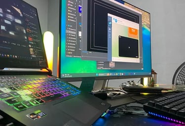 Professional gaming setup with an RGB backlit laptop, secondary monitor, and mechanical keyboard on a desk.