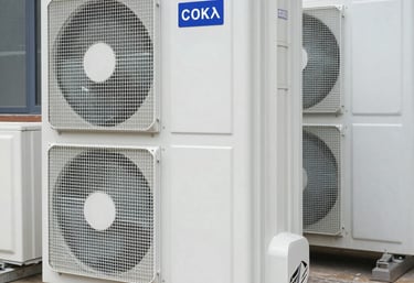 Technician in black uniform with electric gold accents repairing a high-end Sub-Zero refrigerator in a sleek modern kitchen.
