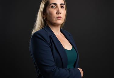 Professional woman with blonde hair wearing a navy blue blazer in a studio portrait.