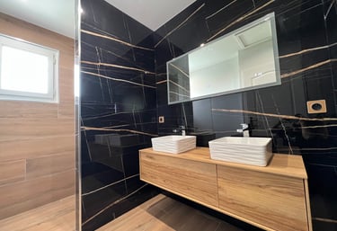 Salle de bain moderne avec double vasque et carrelage effet marbre.