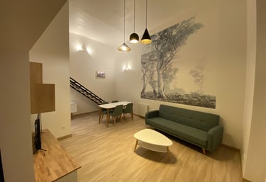 Séjour rénové avec papier peint panoramique, salon contemporain et espace salle à manger.