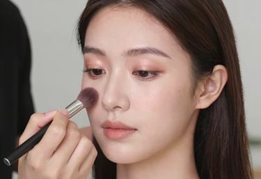 Close-up of a woman with soft glam makeup highlighting her glowing skin and subtle eyeshadow.