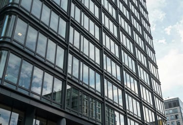 An exterior view of a modern glass and steel commercial building in a Central European business district, symbolizing growth and professional reach.