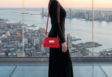Model showcasing the luxury Mini Sirius crystal handbag against the New York City skyline
