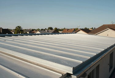 A wide angle shot of a clean, newly renovated rooftop with elegant zinc finishes and a new gutter system, under a clear sky, European / French suburbs.