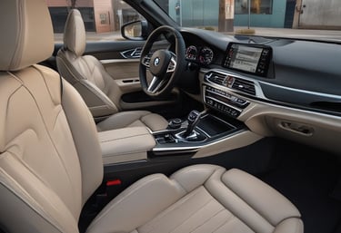Close-up of a shiny supercar's front grille and headlights under bright sunlight.