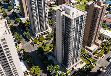 High-angle shot of a premium residential area in Guadalajara with lush green avenues and modern luxury apartment towers, bright daylight.