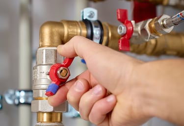 Absperrventil an Heizungsanlage wird von Hand geöffnet oder geschlossen – moderne Gebäudetechnik