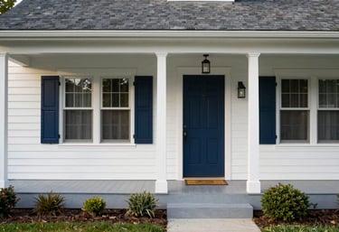 Photography of a beautifully maintained North American home exterior with a clean porch and dark blue front door during the day.