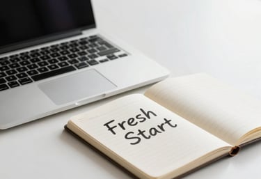 A clean, organized professional desk with a laptop and a notebook, symbolizing a fresh start in a North American / US office with soft natural light.