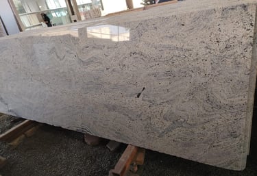 Polished slab of white wave granite with grey veining for custom kitchen countertops and flooring.
