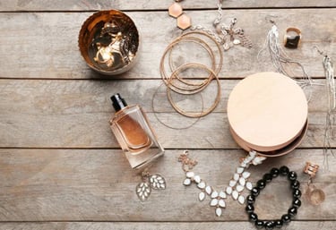 Joyería colocada junto a perfume y accesorios, ejemplo de cuidado para evitar químicos y conservar las piezas por más tiempo.