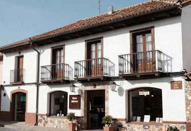 A friendly small business owner working on a laptop surrounded by local shop items.