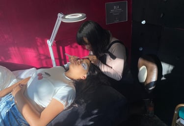 Artista profesional de pestañas aplicando extensiones de pestañas individuales a una clienta