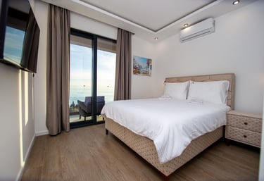 Bright sea view bedroom with terrace doors and comfortable king bed at luxury villa Montenegro