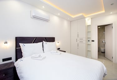 Elegant ground floor bedroom with queen bed and access to jacuzzi bathroom at Villa Aurora Azure