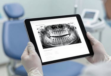 Soft-focus image of a digital tablet showing a patient's dental records, held by a professional in white gloves, signifying modern management.