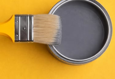 a paintbrush brush with a tin canister of paint